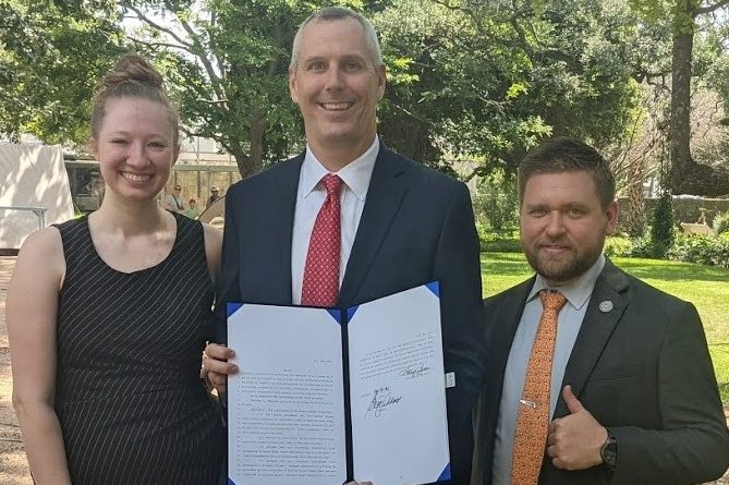 Bethany Young and Chris McNutt with Representative Matt Schaefer holding a copy of the Constitutional Carry bill.